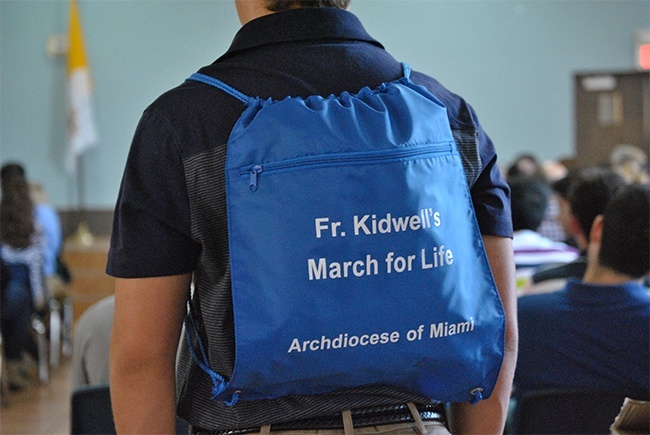 Peter Cooper, a senior at Christopher Columbus High School in Miami, wears the identifiable "Marian Blue"  backpack given out to the Archdiocese of Miami high school pilgrimage group. The backpacks bear the name of the founder of the archdiocesan school pilgrimage, Jesuit Father William Kidwell.