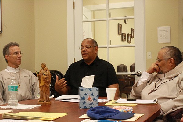 Los mentores del Proyecto José, el Hno. Chris Handal, un novicio de Franciscanos por la Vida, y Joseph King,
al centro, hablan acerca de su trabajo mientras el Superior de los Franciscanos, el Hno. Jay Rivera, escucha.