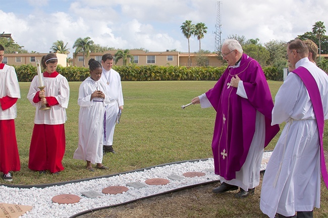 Father Brendan Dalton, St. Bernadette's pastor and supervising principal at Archbishop Edward McCarthy High School, blesses the new rosary garden at the Hollywood church.