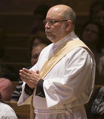 Deacon Pedro Toledo stands after being called up for ordination by Archbishop Thomas Wenski.