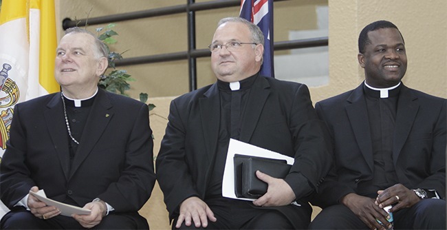 From left: Miami Archbishop Thomas Wenski, Auxilary Bishop-elect Peter Baldacchino and archdiocesan chancellor Msgr. Chanel Jeanty await the start of the press conference.