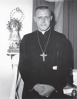 Mons. Boza Masvidal junto a una pequeña imagen de la Virgen de la Caridad del Cobre, Patrona de Cuba.