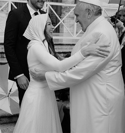 Melissa Ulloa sonríe al Papa Francisco después de darle un abrazo.