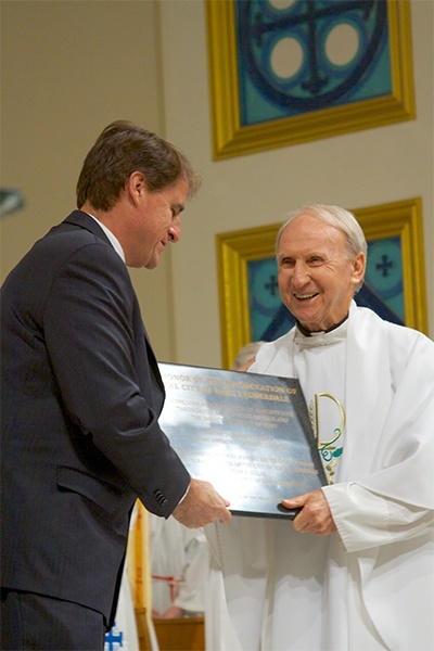 At the conclusion of the Mass, Mayor Jack Seiler presents St. Anthony’s pastor, Father Jeremiah Singleton, with a plaque commemorating the consecration.