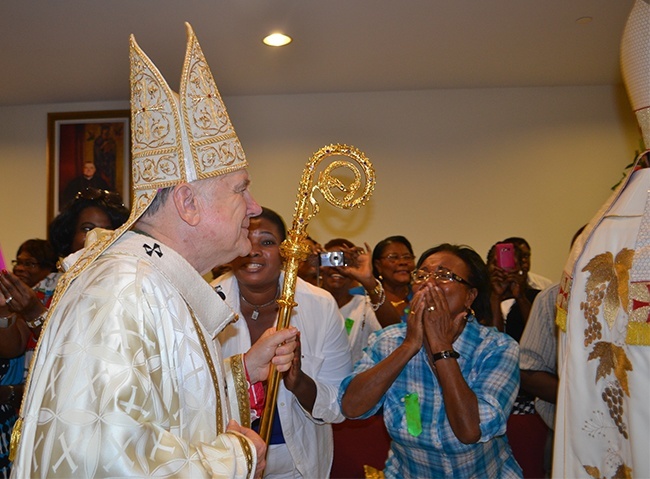 Parishioners react as Archbishop Thomas Wenski walks into Notre Dame d'Haiti Church for the dedication Mass.