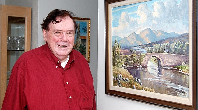Father Martin Cassidy shows a painting of an Irish countryside hanging in his retirement home in Lauderdale-By-The-Sea.