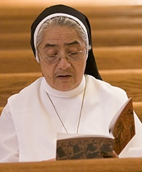 Sister Enith Montero of the Dominicans of the Immaculate Conception who work at St. Cecilia Church in Hialeah, looks over the ordination program.