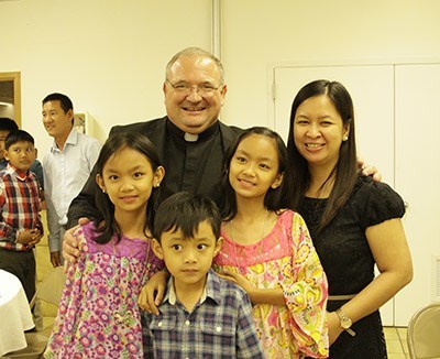 Mons. Baldacchino posa con una familia de las Filipinas, que vive en las Islas Turcas y Caicos donde �l tuvo un ministerio por 15 a�os.