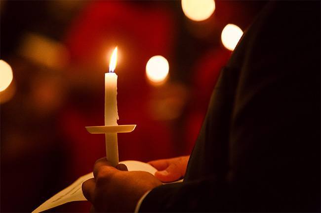 Miami Catholics hold a candle at the start of the annual Easter Vigil Mass April 19 at St. Mary's Cathedral in Miami.