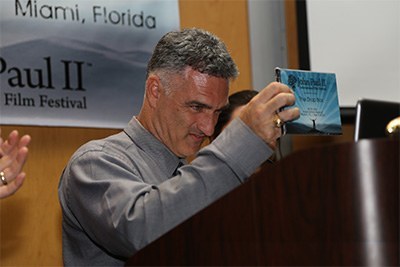 Rafael Anrrich, the film festival's co-founder, presents the "Inspiration" award to "The Drop Box." Nicknamed "the godfather" of the film festival, he works as a mental/behavioral health therapist.