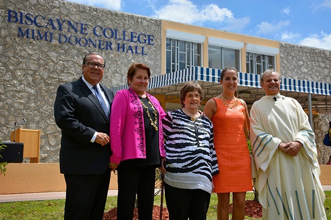 Posing for a photo in the front of the newly renamed Mimi Dooner Hall, from left: John Dooner, Cindy Dooner, Myriam Van Scoter, Jacqueline Dooner and Msgr. Franklyn Casale.
