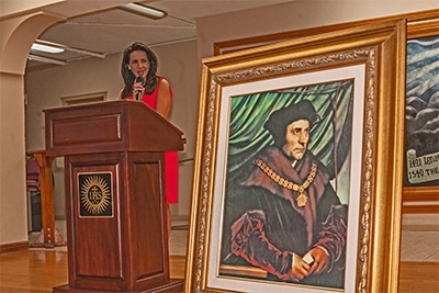 Circuit Judge Beatrice Butchko address legal professionals during the reception that followed the Red Mass. A painting of St. Thomas More is in the foreground. Judge Butchko is the one handing the award to Lex Christi, Lex Amoris award to William VanderWyden in the photo that appears on the archdiocese's home page.