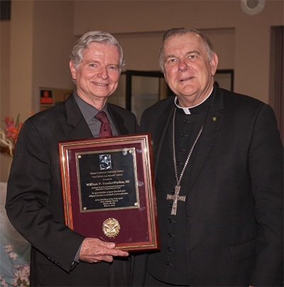 William VanderWyden holds his Lex Christi, Lex Amoris award his posing for a photo with Archbishop Thomas Wenski.