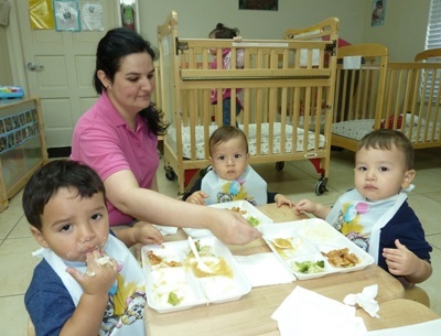 Odelay Bermudez, caretaker at Centro Mater for 13 years, feeds infants- from left to right: Valentin Rodriguez, Aithan Rivera and Nathan Herrera.