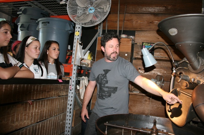 Joel Pollock of Panther Coffee shows Archbishop McCarthy students how the Café Cocano coffee they brought in is roasted.