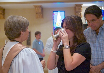 Longtime parishioner Kathy Bustamante receives holy Communion during the Corpus Christi Mass at Blessed Trinity Church in Miami Springs.