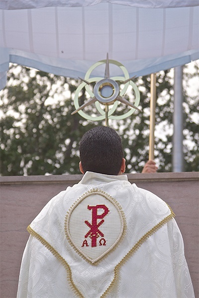 El P.  José Alfaro, administrador de Blessed Trinity, se arrodilla en reverencia, durante la adoración de la Eucaristía, al finalizar la procesión del Corpus Christi, el 21 de junio.
