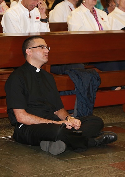 Newly ordained transitional Deacon Javier Barreto, from the Archdiocese of Miami, sits in front of the altar praying the rosary during the all night vigil on the solemnity of the Sacred Heart of Jesus and the feast of the Immaculate Heart of Mary.