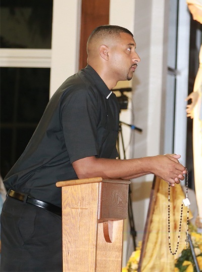 Father Joshua Johnston from the diocese of Baton Rouge, ordained only three weeks ago, kneels in front of the Blessed Sacrament while praying the rosary.