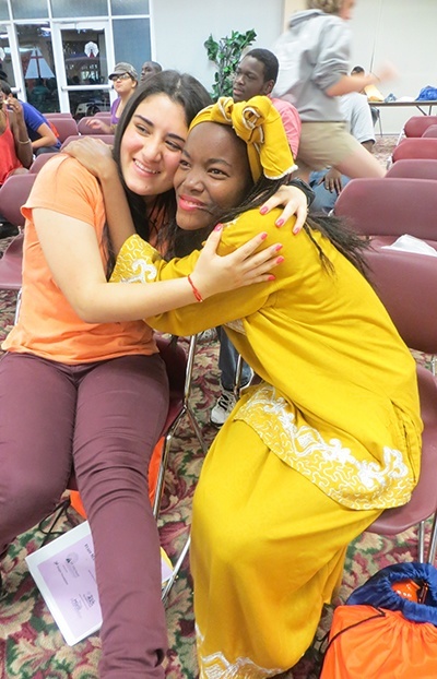 MetroTown delegates Lena Zuluaga and Jennifer Willis hug during cultural night.