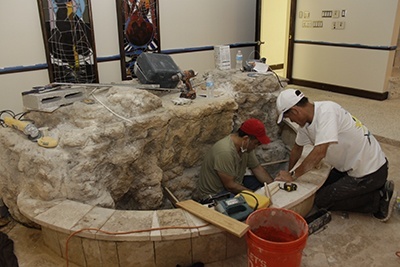 Volunteer workers finish a baptismal pool in the back of the old St. Charles Borromeo Church. The walk-in pool that had been there before took up too much space. The work took two days and six laborers, led by a Vietnamese contractor, Amy Le, who volunteered her time and labor.