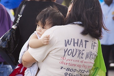 Dempuls Glabog, from Little Flower Church in Hollywood, holds her grandson, Peter Frances Romel Glabog, while she prays the rosary during a ceremony commemorating the National Day of Remembrance for aborted children.
