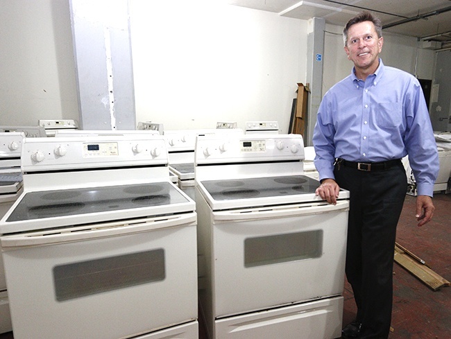 Vincentian Dennis Joseph poses with some of the 175 donated stoves that remain to be distributed to anyone in need.