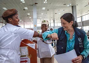 Safer than shaking hands, Dr. Aileen Marty bumps elbows with a Lagos International airport employee.
