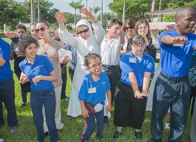Sister Fausta, one of the Sisters of St. Joseph Benedict Cottolengo who work at the Marian Center, sings and motions to "Together We Can" along with students Tiziana Gravina, Chelsea D'Costa, Valerie Virgil, Tyrone Williams and others.