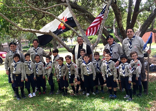 Father Jesus Arias, pastor of Good Shepherd, poses with leaders and members of the Stella Maris Otters as the boys proudly display the patches they received after making their promise as Otters.