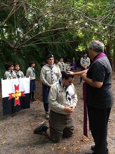 Ramon Rodriguez receives a blessing from Father Jesus Arias during his "promise ceremony" and installation as new assistant Otter leader. Jorge Escala, one of the founders of the Stella Maris Federation of North American Explorers, looks on along with several Timber Wolves.