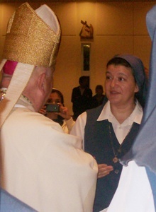 Sister Marlyn Monge speaks to Archbishop John C. Favalora after the 50th anniversary Mass.