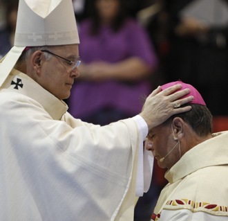 Archbishop Charles Chaput of Denver lays hands upon Fernando Isern, consecrating him to the fullness of the priesthood as bishop.